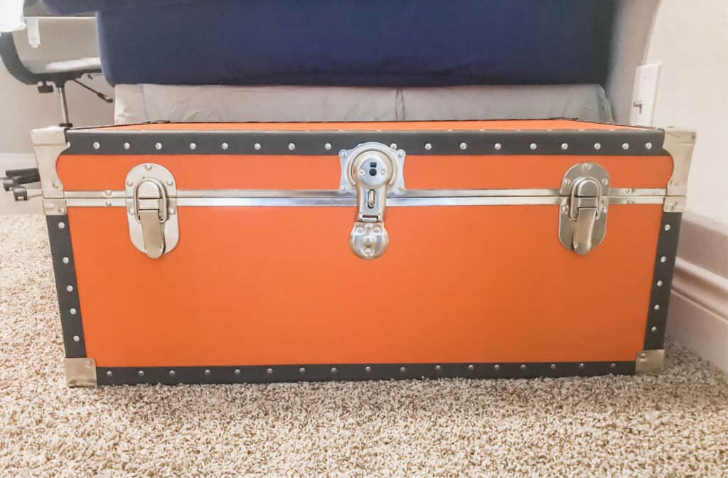 Organizing a kid's bedroom using an orange trunk