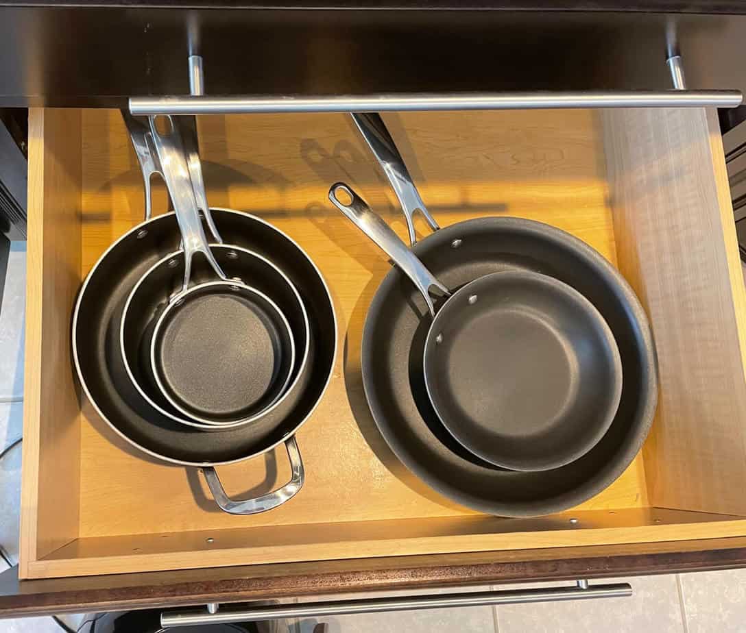 An organized kitchen drawer full of pots and pans