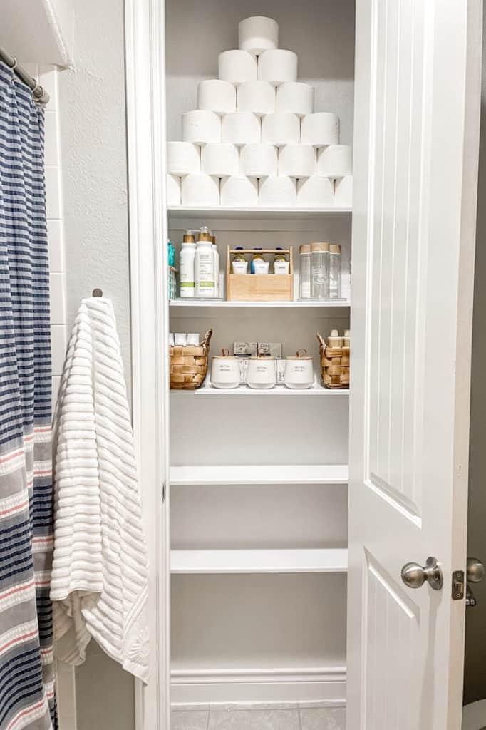 A very organized bathroom storage closet with bamboo organizing containers