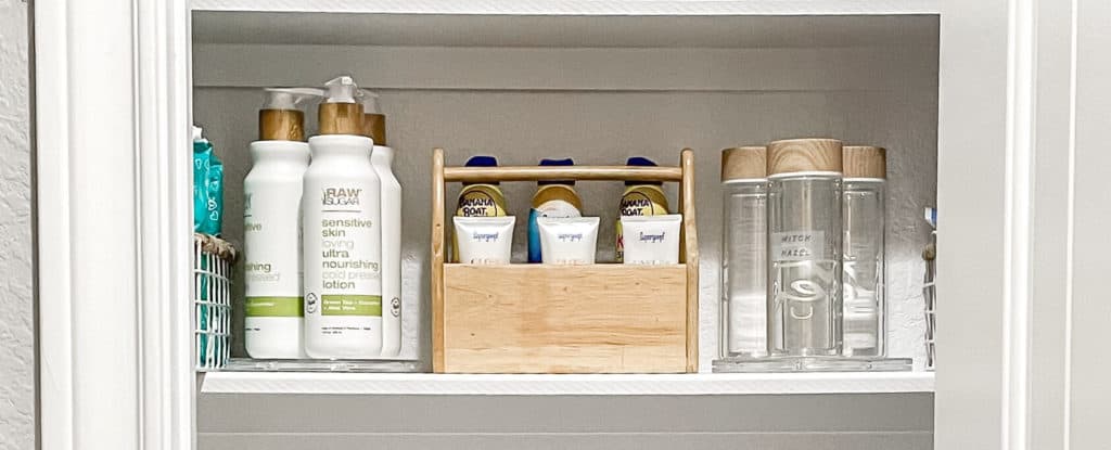 Extremely organized bath storage. A shelf with organizing turntables and a bamboo caddy holding skincare products