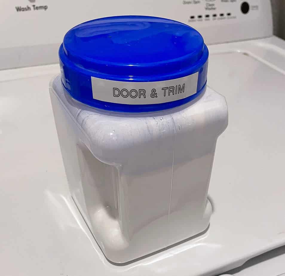 A plastic container holding white paint